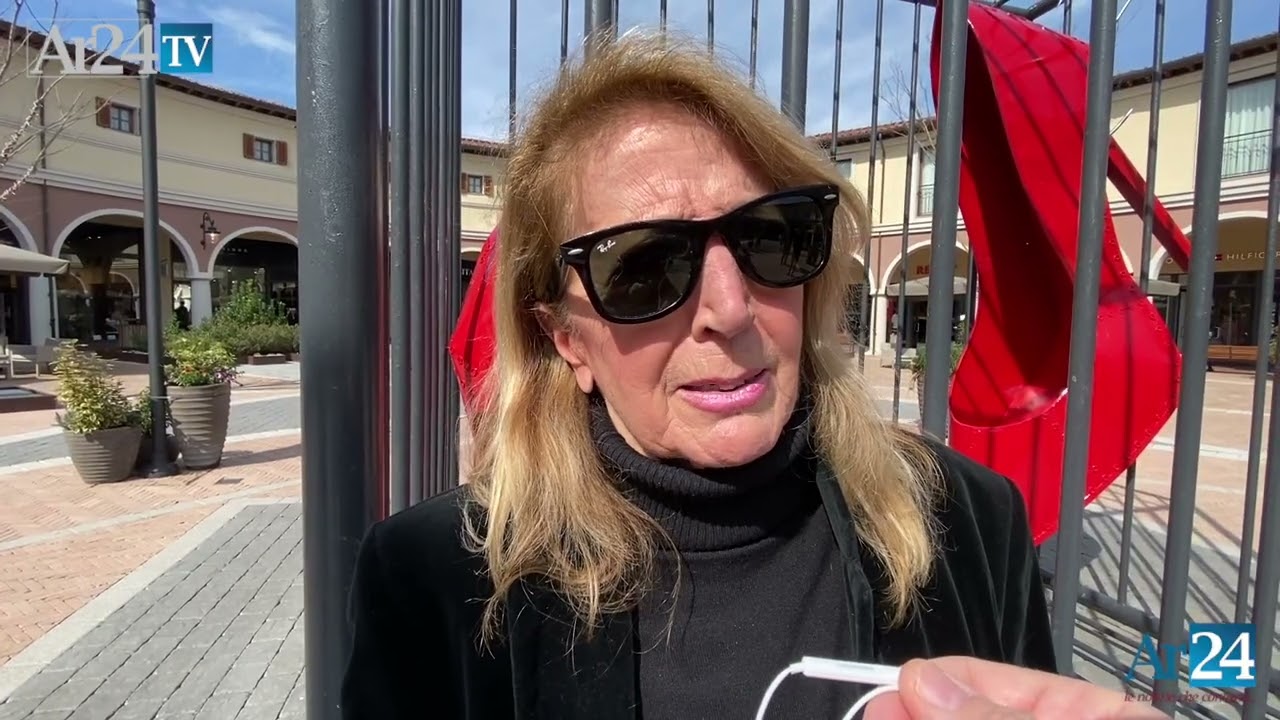 L'artista Anna Izzo di fronte all'opera "La violenza è una gabbia" installata a Valdichiana Village